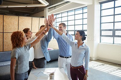 Buy stock photo Cropped shot of a group of businesspeople high fiving in the office