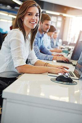 Buy stock photo Cropped portrait of a young businesswoman working in the office with her colleagues