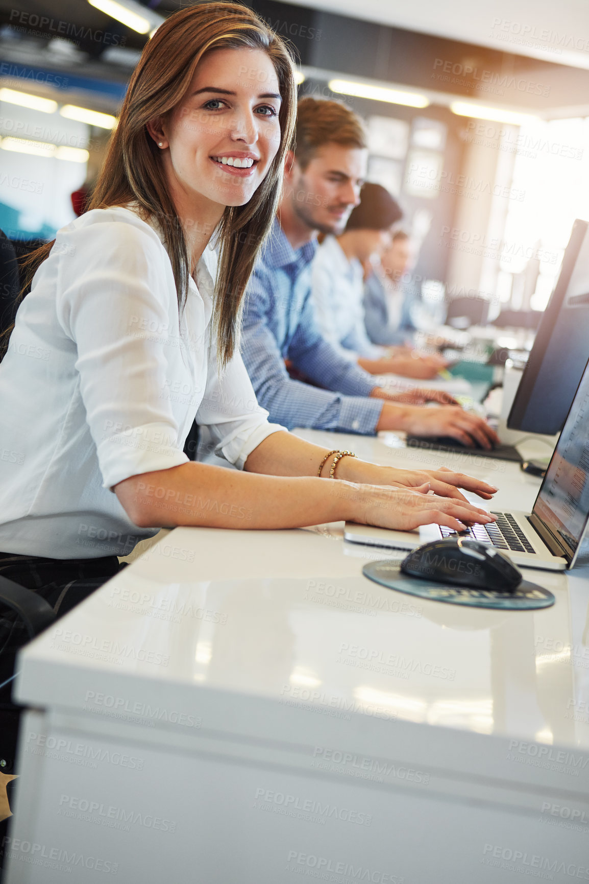 Buy stock photo Cropped portrait of a young businesswoman working in the office with her colleagues