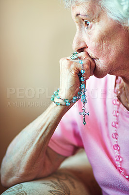 Buy stock photo Cropped shot an elderly woman holding a rosary in prayer