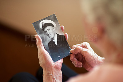 Buy stock photo Cropped shot an elderly woman holding an old black and white photograph of a man