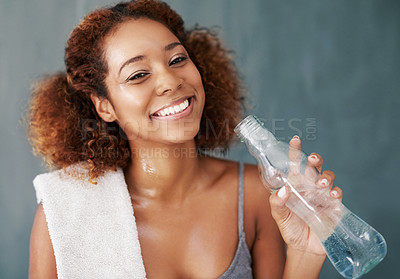 Buy stock photo Studio portrait of a young woman drinking some water after yoga class against a grey background