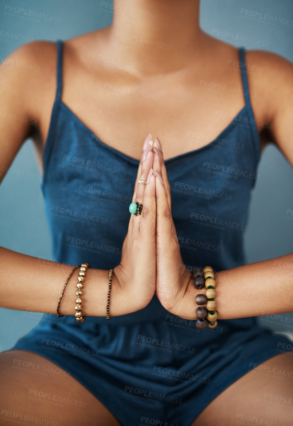 Buy stock photo Cropped shot of a young woman meditating against a grey background