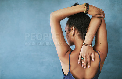 Buy stock photo Rearview shot of a young woman stretching before yoga class