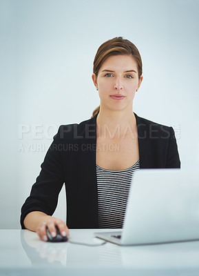 Buy stock photo Studio portrait of a young businesswoman working on her laptop