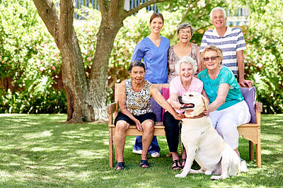 Buy stock photo Portrait of a group of smiling seniors and a nurse outside with a labrador