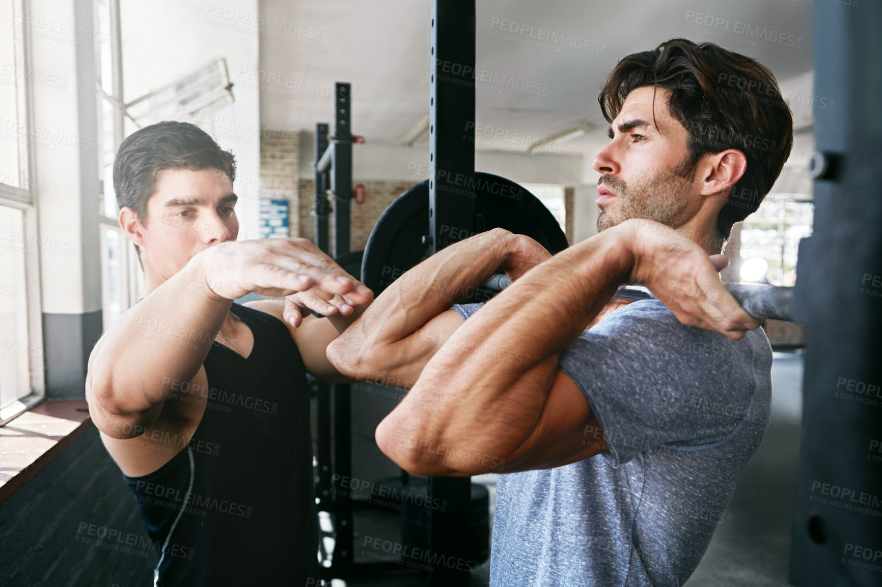 Buy stock photo Shot of young men working out with weights in the gym