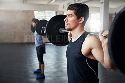 Buy stock photo Shot of young men working out with weights in the gym