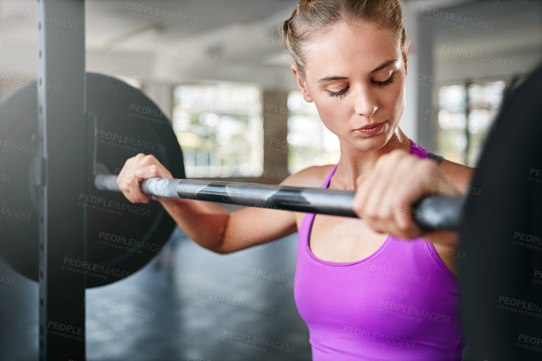 Buy stock photo Shot of a young woman working out with weights at the gym