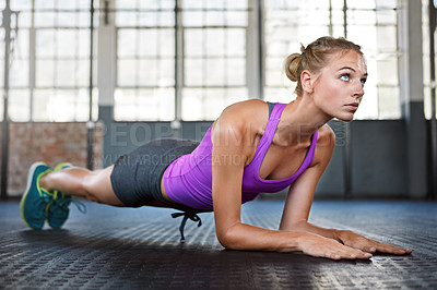 Buy stock photo Shot of a sporty young woman doing push-ups at the gym