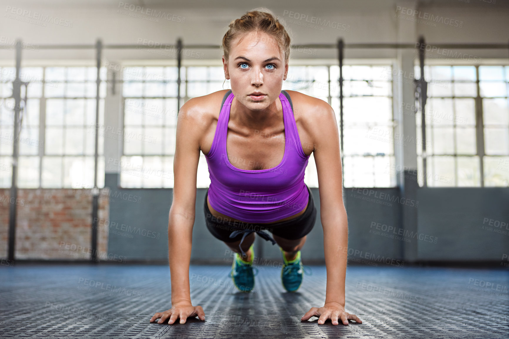 Buy stock photo Shot of a sporty young woman doing push-ups at the gym