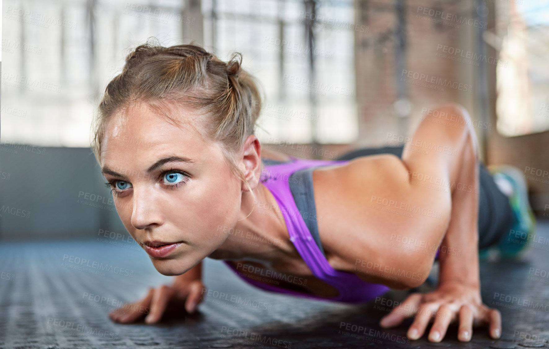 Buy stock photo Shot of a sporty young woman doing push-ups at the gym