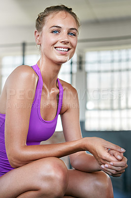 Buy stock photo Shot of a sporty young woman taking a break after her workout