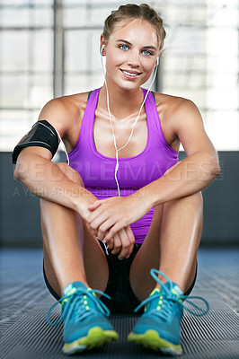 Buy stock photo Shot of a sporty young woman taking a break after her workout
