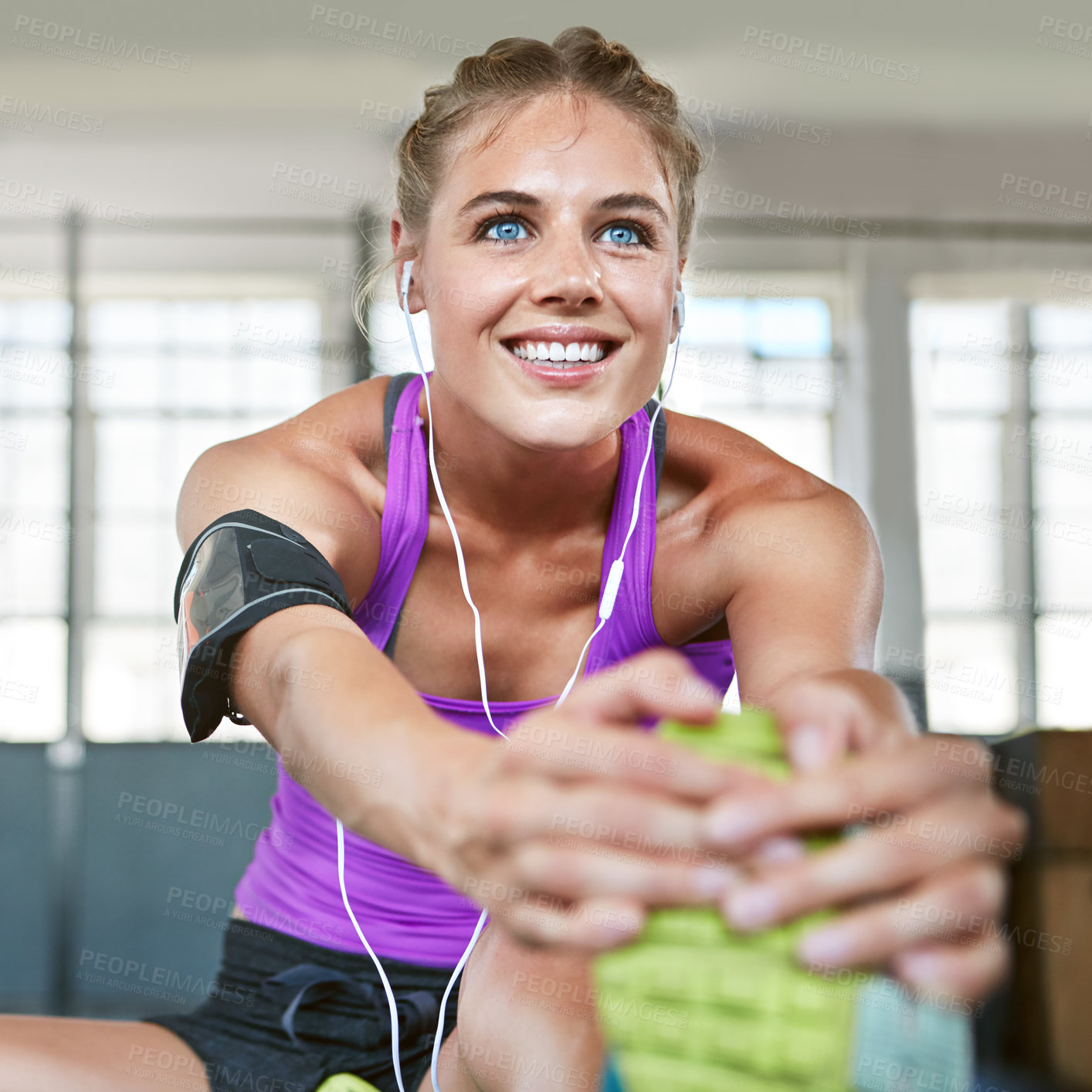 Buy stock photo Shot of a sporty young woman stretching before her workout