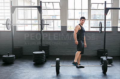 Buy stock photo Shot of a young man working out with weights in the gym