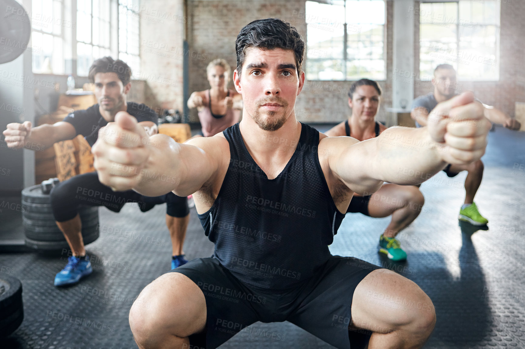 Buy stock photo Shot of a group of people doing squats in a gym