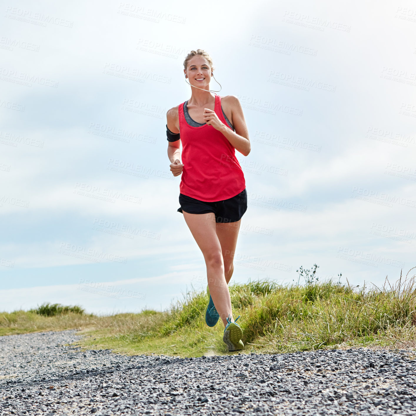 Buy stock photo Shot of a young woman jogging near the ocean