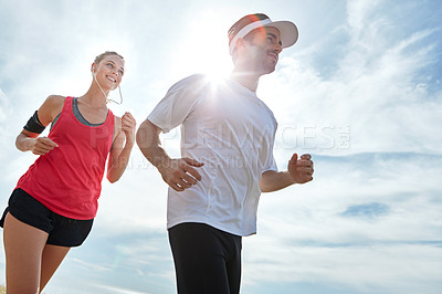 Buy stock photo Shot of a young couple going for a run together