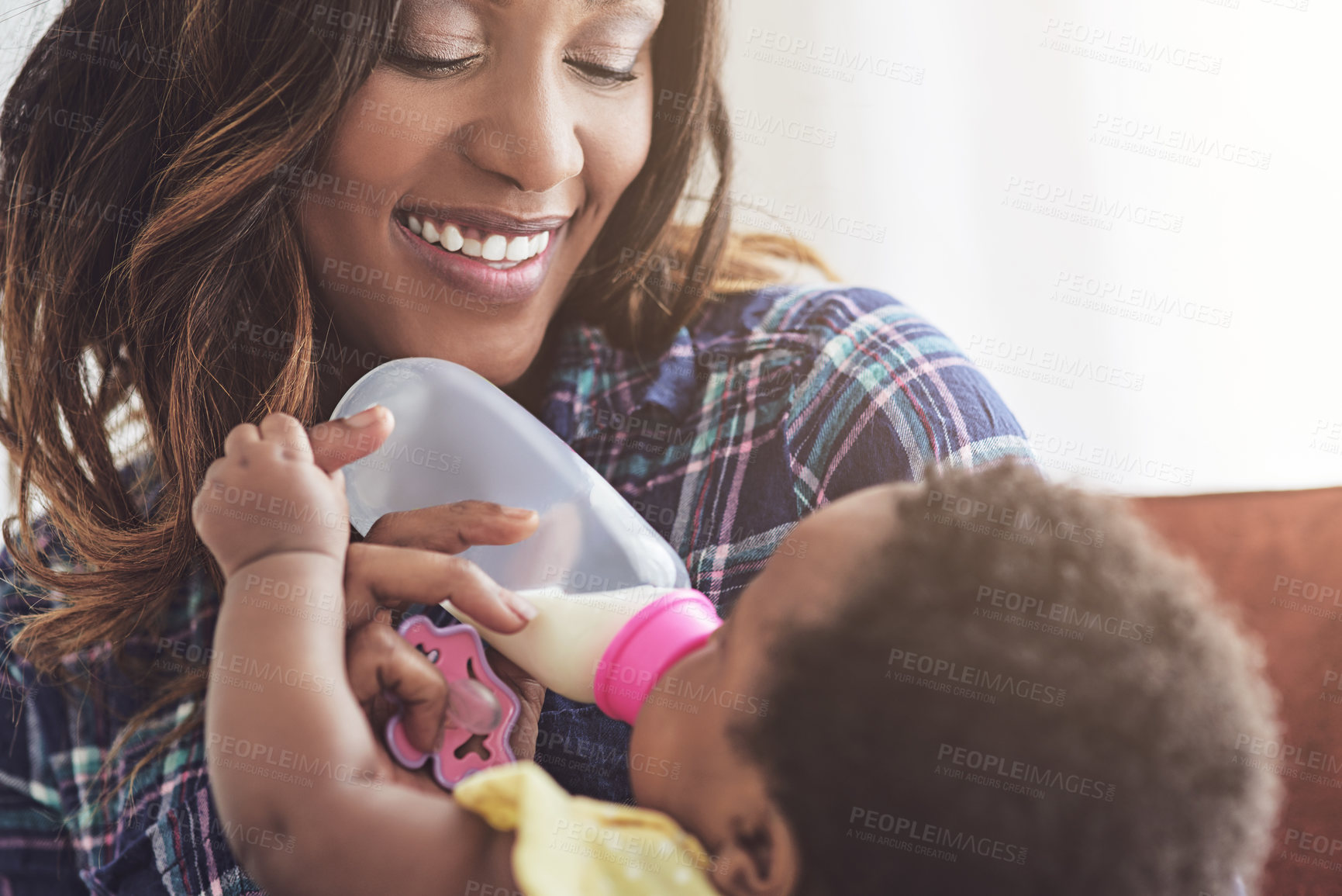 Buy stock photo Cropped shot of a young mother feeding her baby girl at home