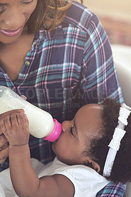 Buy stock photo Cropped shot of a young mother feeding her baby girl at home