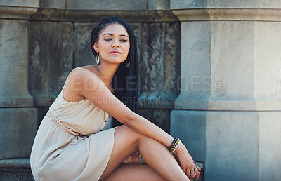 Buy stock photo Portrait of a femininely dressed young woman posing against an urban background