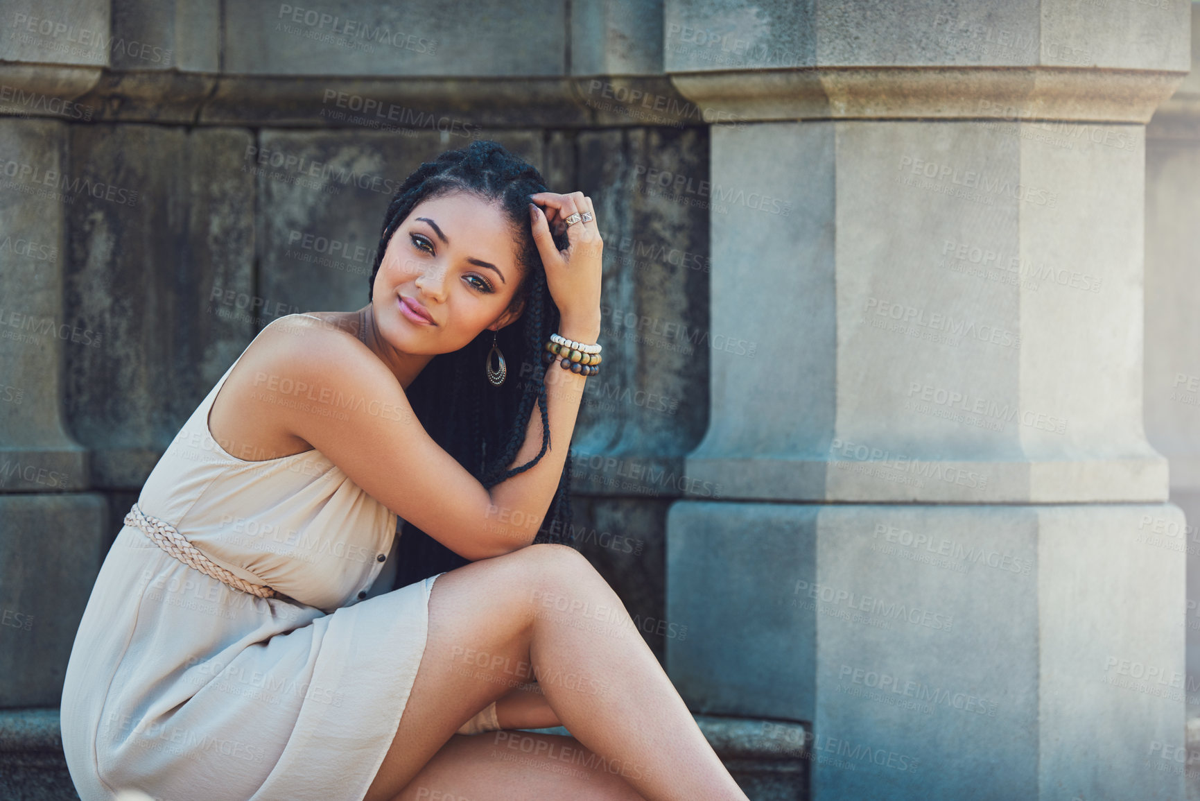 Buy stock photo Portrait of a femininely dressed young woman posing against an urban background