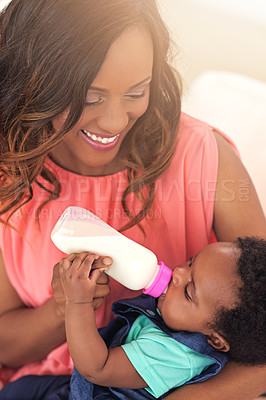 Buy stock photo Cropped shot of a young mother feeding her baby girl at home