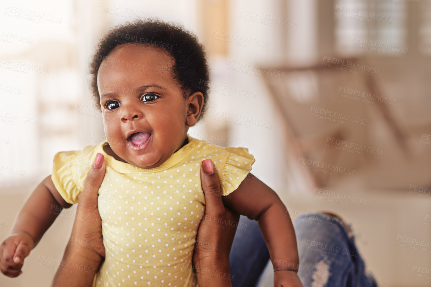 Buy stock photo Shot of a baby girl looking happy as her mother holds her up