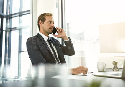 Buy stock photo Shot of a businessman talking on his cellphone in an office