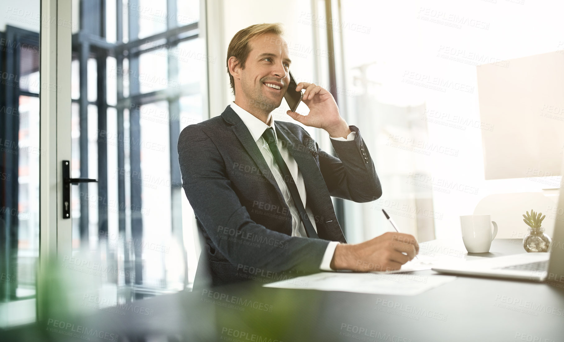 Buy stock photo Shot of a businessman talking on his cellphone in an office