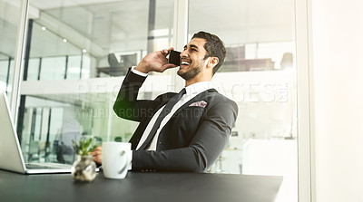 Buy stock photo Shot of a businessman talking on his cellphone with his laptop in front of him