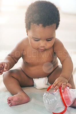 Buy stock photo Children, black baby and girl with a bottle sitting on a blanket on the floor of a home for child development. Kids, cute and curious with a newborn infant learning or growing alone in a house