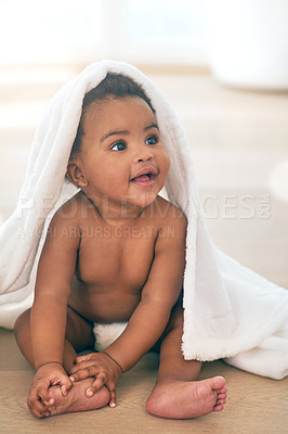Buy stock photo Shot of an adorable baby girl covered in a towel at home