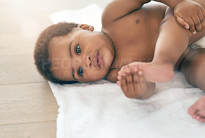 Buy stock photo Baby, girl and development or growth of child on a blanket on home floor to relax and play. Healthy black kid in room with hands on feet or skin for health and wellness while curious and playful
