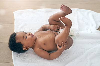 Buy stock photo Black girl, towel and kids with a baby in a home, lying on the floor for growth or child development. Relax, children and family home with a newborn infant playing in the living room of a house