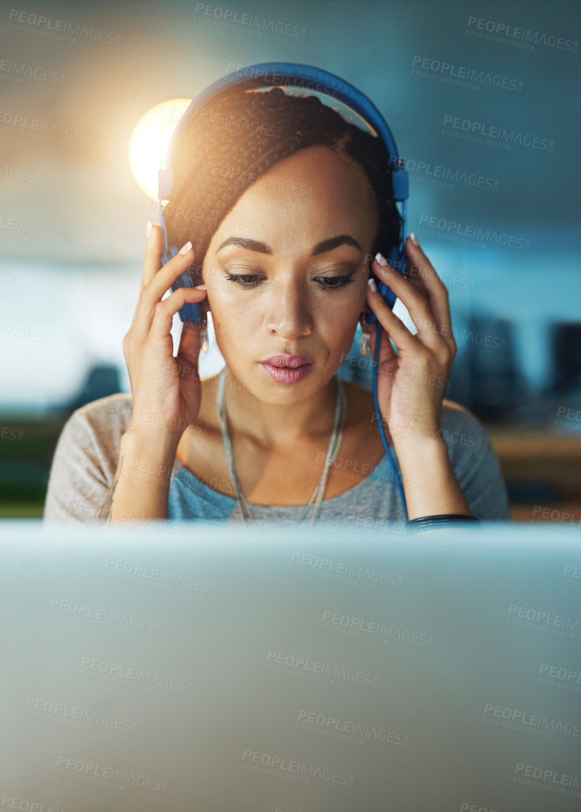 Buy stock photo Cropped shot of a young woman listening to music while working late in her office