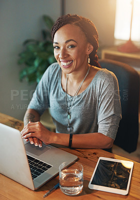 Buy stock photo Cropped portrait of a young woman using her laptop while working late in her office
