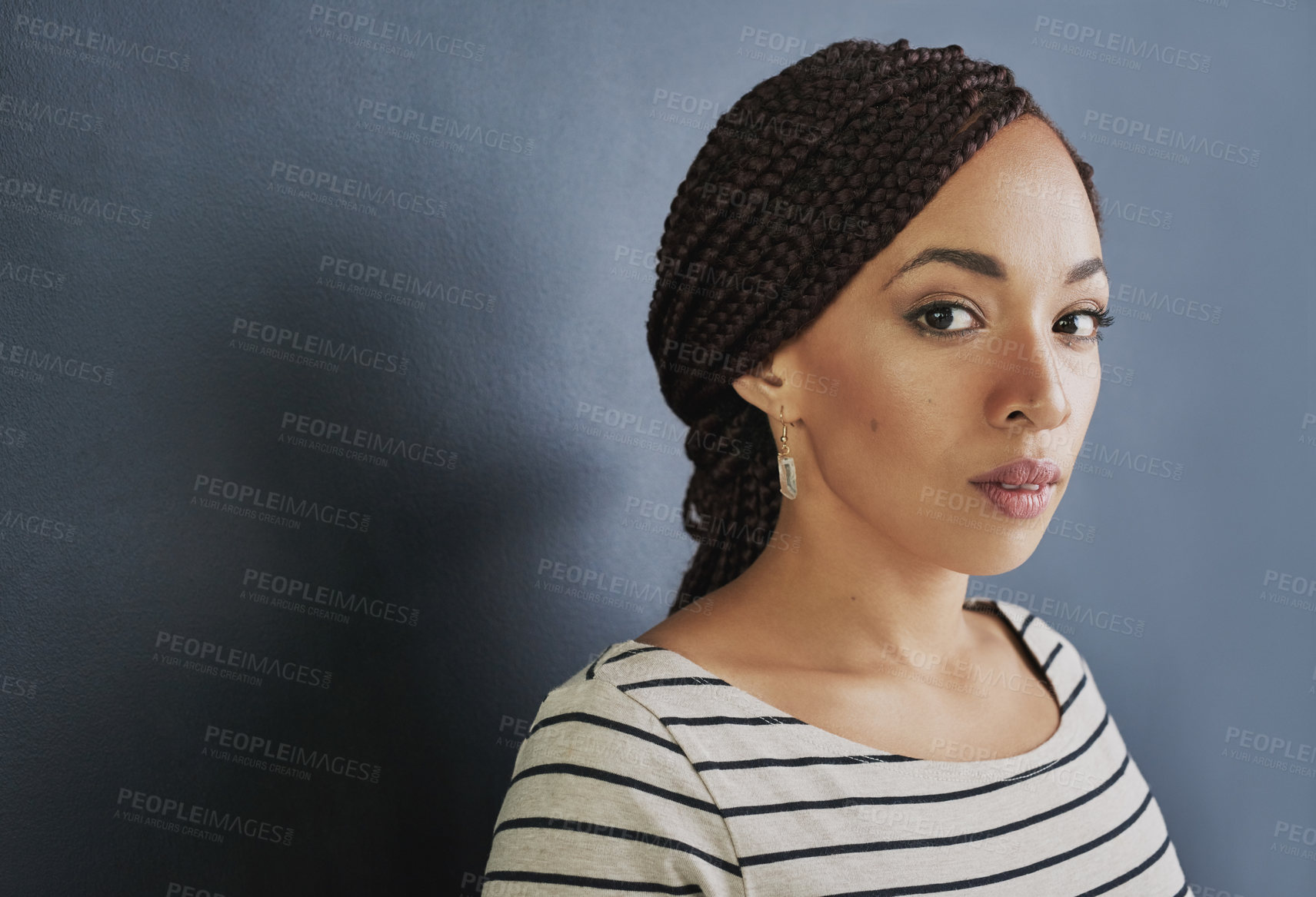 Buy stock photo Studio shot of a young woman standing against a dark background