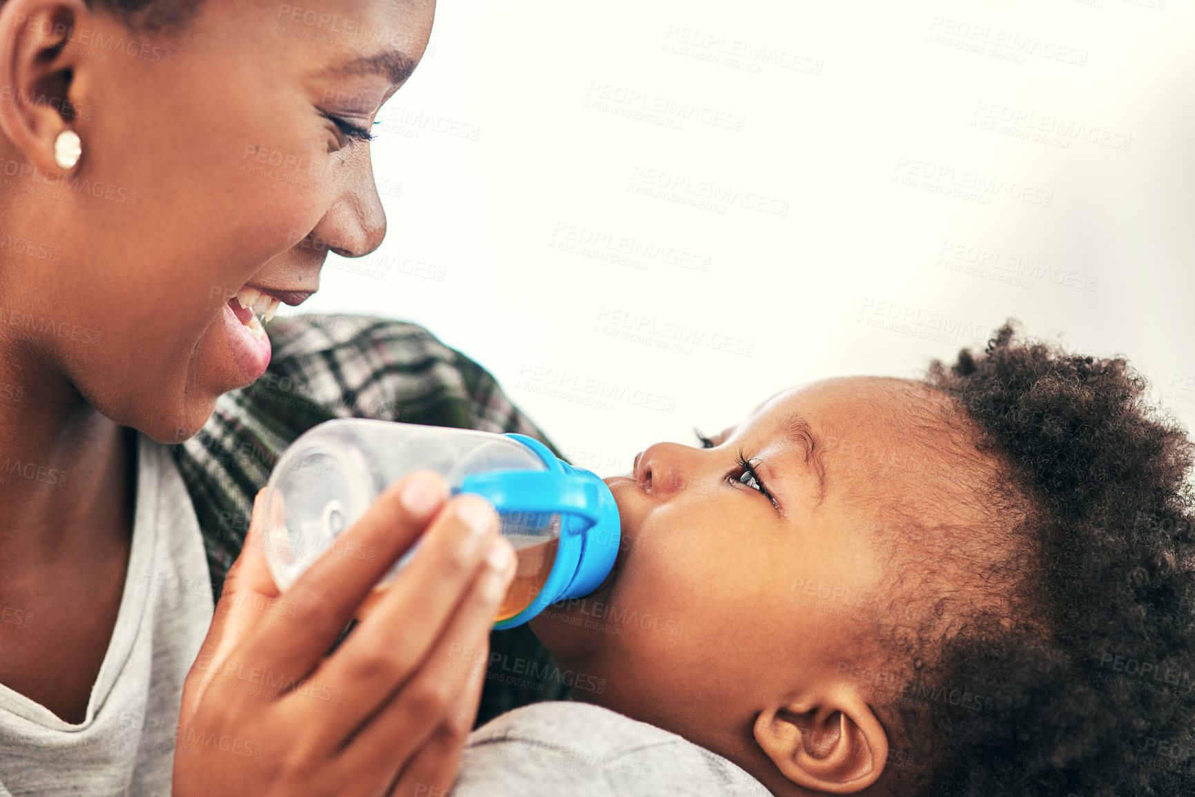 Buy stock photo Shot of a mother giving her little baby boy a bottle