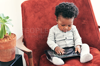 Buy stock photo Shot of a little baby boy sitting in a chair holding a digital tablet