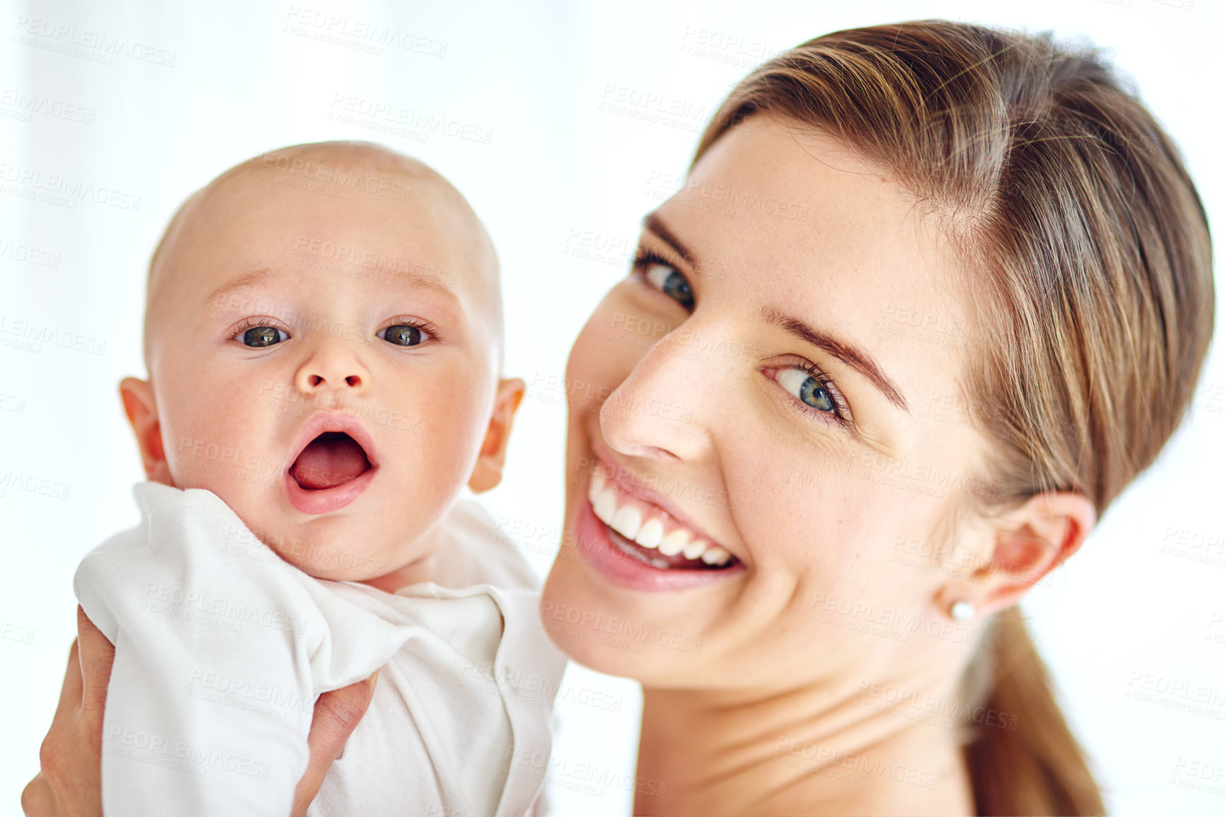 Buy stock photo Cute, adorable baby bonding with mother enjoying quality playtime together at home. Proud, loving and happy woman holding her little newborn child while bonding together against a white background