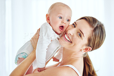 Buy stock photo Mother bonding with her baby boy, smiling and enjoying family time in a home room. Portrait of a happy, loving and caring single parent holding or carrying an adorable, cute and little newborn child 