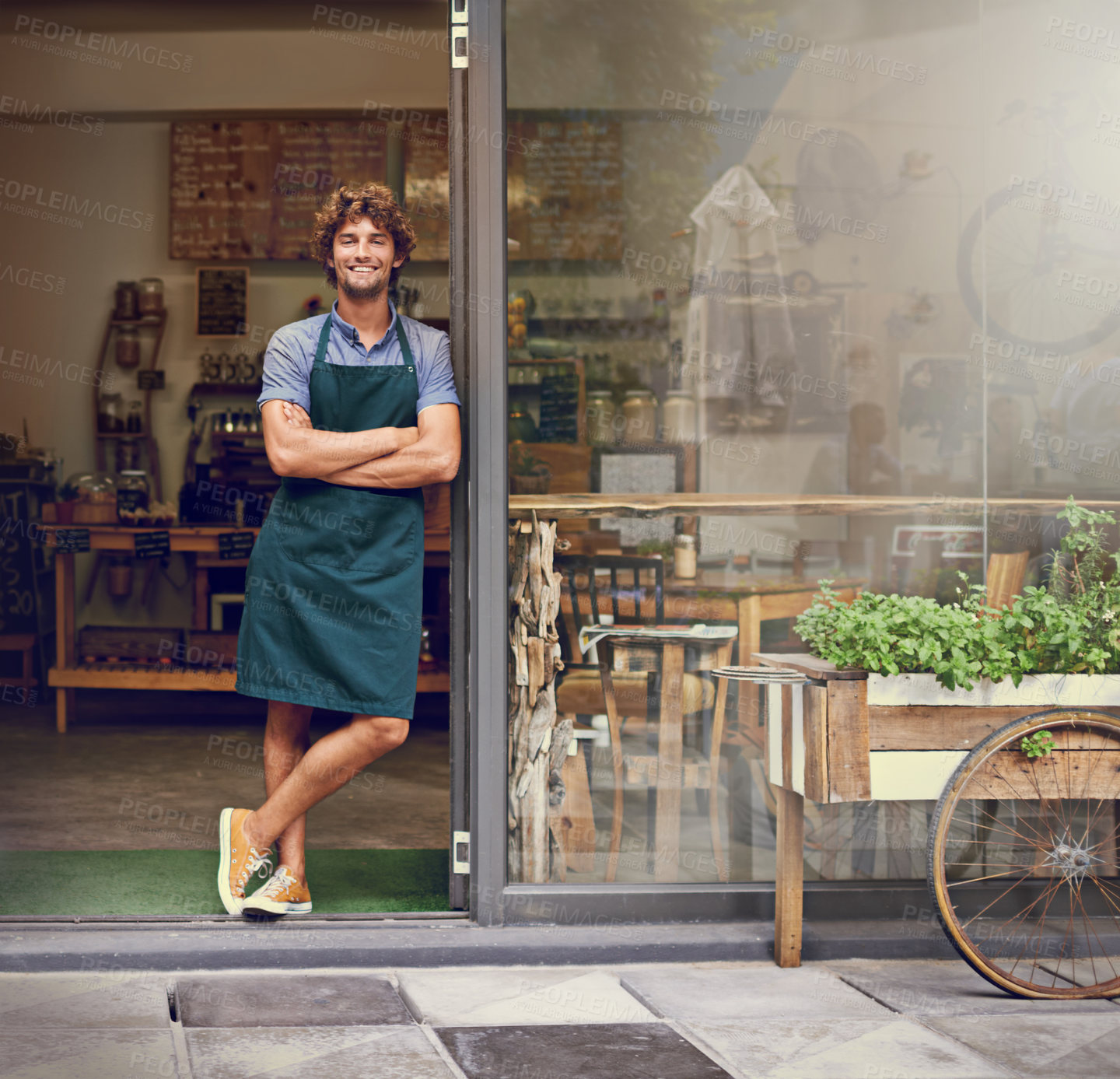 Buy stock photo Portrait of a successful young barista standing in the doorway of a coffee shop