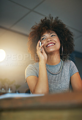 Buy stock photo Shot of a young woman talking on the phone during a late shift at the office