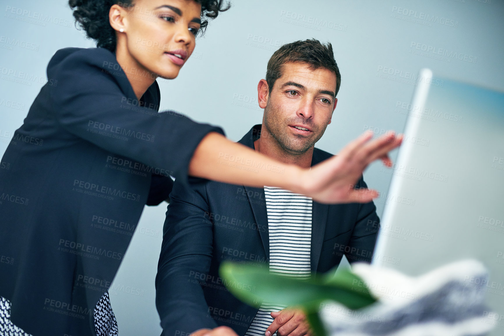 Buy stock photo Shot of two coworkers working together at a computer in an office