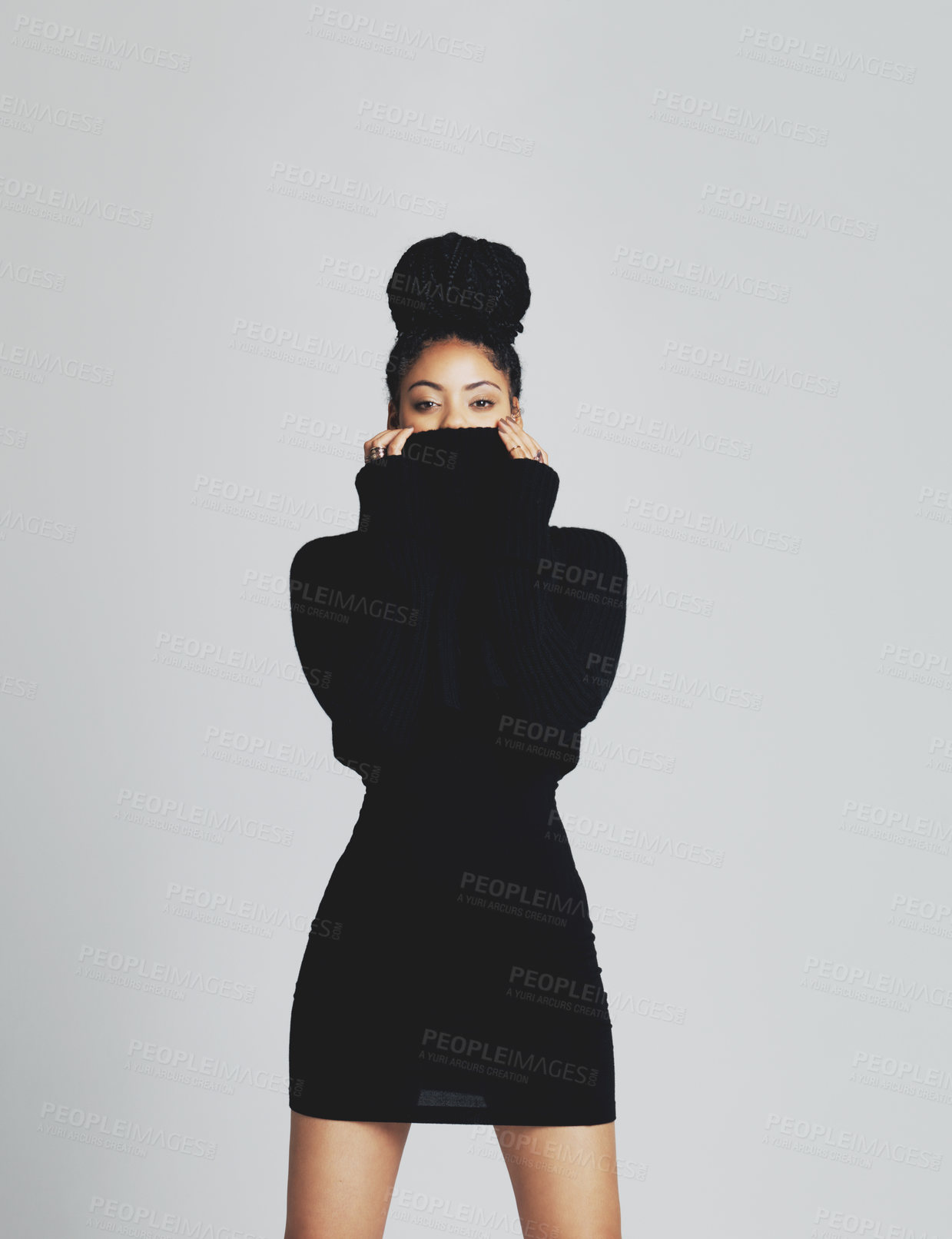 Buy stock photo Studio shot of a fashionable young woman posing in a black dress against a grey background