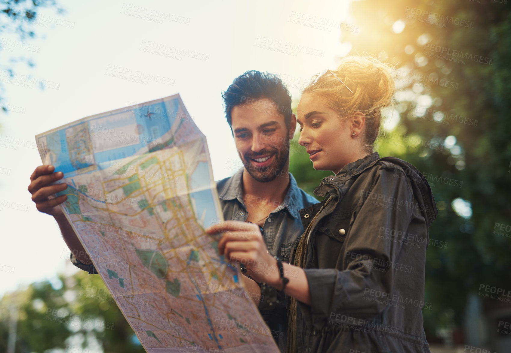 Buy stock photo Shot of a young couple using a map while exploring the city