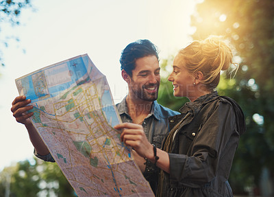 Buy stock photo Shot of a young couple using a map while exploring the city