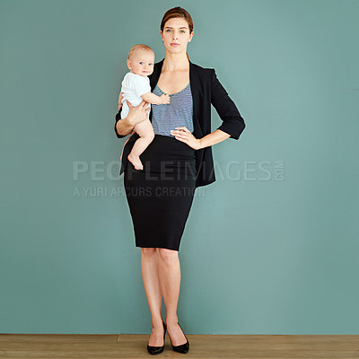 Buy stock photo Studio shot of a successful young businesswoman carrying her adorable baby boy